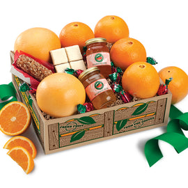 A gift basket containing Navel Oranges, Ruby Red Grapefruit, a Pecan Log, Chocolate Coconut Patties, and two jars of Marmalade, all arranged on a wooden tray with a green ribbon.